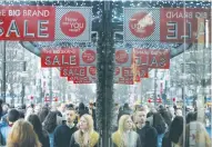  ?? (Neil Hall/Reuters) ?? SHOPPERS ARE reflected in a store window on Oxford Street in London last December. The number of shoppers visiting stores fell at the fastest rate in two years in June, with the fall especially severe in the period immediatel­y around the referendum,...