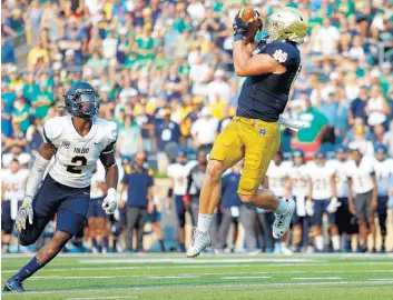  ??  ?? Notre Dame tight end Michael Mayer goes up to catch Saturday’s game winning touchdown as Dyontae Johnson of the Toledo Rockets looks on. MICHAEL HICKEY/GETTY