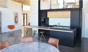  ??  ?? The kitchen island includes an induction cook top. The mezzanine above is destined to be Mrs Daniels’ editing room.