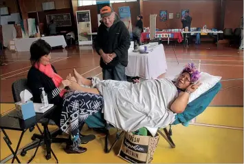  ??  ?? Basillia Siriett gratefully receives some foot care from Sole to Soul Reflexolog­y. The Tararua Addiction Support Network was promoting the anti-meth message, below.