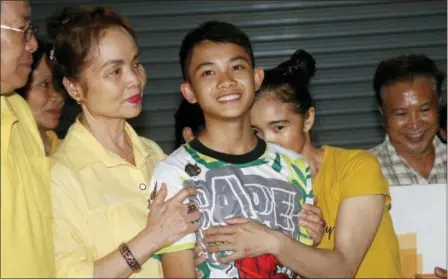  ?? SAKCHAI LALIT — THE ASSOCIATED PRESS ?? Relatives of Duangpetch Promthep, one of the boys rescued from the flooded cave in northern Thailand, greet him as he arrives home in the Mae Sai district, Chiang Rai province, northern Thailand, Wednesday.