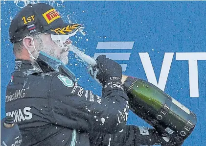  ?? AFP ?? Brindis. Con toda la fuerza del champagne, Valtteri Bottas celebra en el circuito olímpico de Sochi.