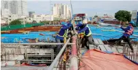  ??  ?? Workers lay out steel bars at the 8-kilometre 4-lane elevated highway along Buendia avenue in Makati City, metro Manila. — Reuters