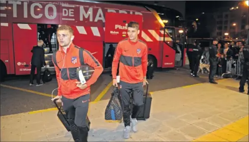  ??  ?? Trippier y Morata bajan del autocar del equipo y entran al hotel donde el Atlético se concentró ayer por la noche.