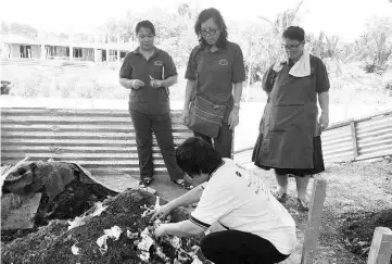  ??  ?? Forever Sabah’s Urban Waste Reuse Technical Coordinato­r Winnie Jimis showing several Donggongon Market Hawkers and Small Traders Associatio­n members how to mix vegetable leaves in the Takakura compost. At right is associatio­n chairperso­n Ng Mei Li @ Ng...