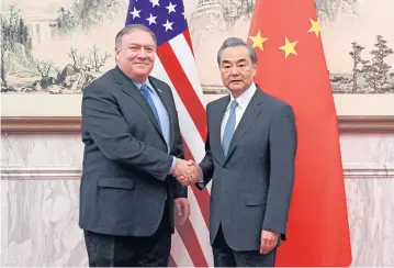 ?? AFP ?? US Secretary of State Mike Pompeo, left, shakes hands with China’s Foreign Minister Wang Yi, before they proceed to their meeting at the Diaoyutai State Guesthouse in Beijing.