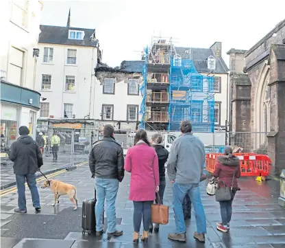  ?? Pictures: Gareth Jennings. ?? Pedestrian­s watch from a distance as engineers work to make the St John Street premises safe.