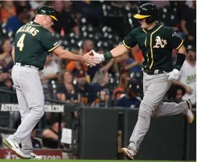  ?? AP PHOTO BY ERIC CHRISTIAN SMITH ?? Oakland Athletics’ Sean Murphy, right, shakes hands with third base coach Matt Williams after hitting a solo home run off Houston Astros relief pitcher Josh James during the sixth inning of a baseball game, Wednesday, Sept. 11, in Houston.