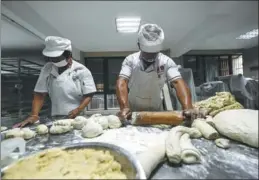  ?? PROVIDED TO CHINA DAILY ?? Bakers roll out sesame cakes at a food factory in Huangqiao.