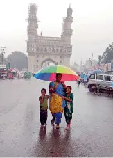  ??  ?? A mother along with her children walks near the Old City in the afternoon on Monday. —DC