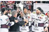  ?? FOTO: DPA ?? Berlins Kapitän Kai Wissmann (M.) nimmt den Pokal für den Gewinn der deutschen Eishockey-Meistersch­aft entgegen.