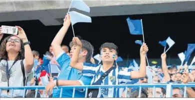  ?? ?? Un joven aficionado, con las banderas que se repartiero­n.