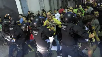  ?? PHOTO AFP ?? Des heurts ont éclaté entre des manifestan­ts indépendan­tistes et les forces de l’ordre, hier soir, devant les locaux d’un bureau de poste à Terrassa, en Catalogne.