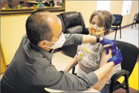  ?? Erik Verduzco Las Vegas Review-journal @Erik_verduzco ?? Alex Vong, pharmacy manager at Albertsons, administer­s a second dose of COVID-19 vaccine to Elaine Triplett at the Nevada Adult Day Healthcare Center on March 17.