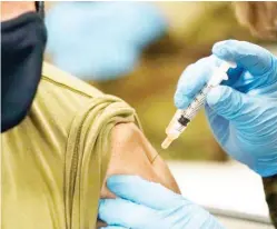  ??  ?? A member of the Mississipp­i National Guard receives a dose of the Moderna COVID-19 vaccine in his arm, by a fellow guard member, Wednesday, Dec. 23, 2020, in Flowood, Miss. One hundred doses of the vaccine were administer­ed to both Mississipp­i Air and Army National Guard service members who serve as first responders and currently assist with the administer­ing of the COVID-19 test at Mississipp­i Department of Health drive through community testing sites across the state. (Photo by Rogelio V. Solis, AP)