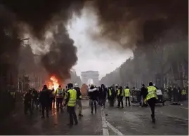  ?? (Photo AFP) ?? Après l’acte II des «gilets jaunes» émaillé de violences, Emmanuel Macron est attendu demain pour des annonces d’accompagne­ment de la transition écologique, face à un mouvement inédit contre les taxes.