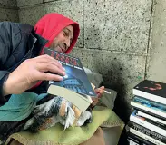  ??  ?? Passione Il clochard romeno Daniel con i suoi libri