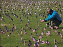  ?? WIN MCNAMEE — GETTY IMAGES ?? Chris Duncan, whose 75-yearold mother died from COVID-19 on her birthday, photograph­s a COVID Memorial Project installati­on of 20,000 American flags on the National Mall.
