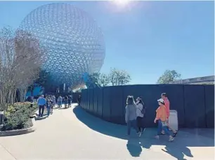  ?? DEWAYNE BEVIL/ORLANDO SENTINEL ?? Epcot visitors walk toward Spaceship Earth and past the latest constructi­on wall near the entrance of Walt Disney World’s second-oldest theme park.