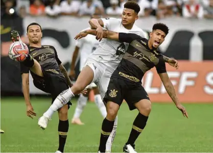  ?? Ivan Storti/santos FC ?? ■ O atacante santista Felippe Cardoso (centro) disputa a bola sob a marcação dos corintiano­s Douglas (à dir.) e Thiaguinho durante um amistoso de pré-temporada disputado, em Itaquera, entre Corinthian­s e Santos