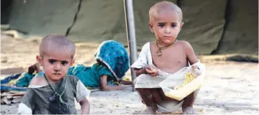  ?? Associated Press ?? ±
Children, displaced by flooding from monsoon rain, eat food at a temporary camp in Sukkur, Sindh province, on Saturday.