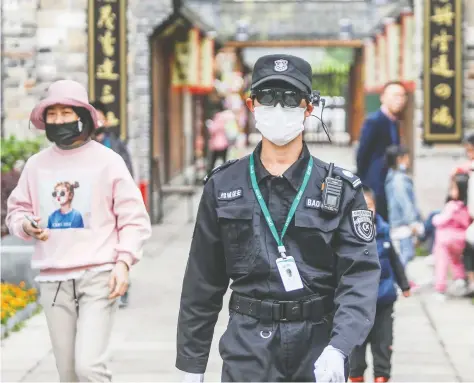  ?? AFP VIA GETTY IMAGES ?? A security officer wears an augmented reality headset to measure a person’s body temperatur­e at a park in Hangzhou, China, last week. The emergence of COVID-19 has been a public-relations disaster for China, an emerging superpower keen to bolster its internatio­nal influence and prestige.