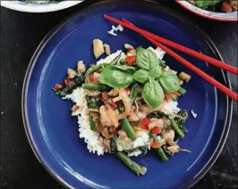  ?? GRETCHEN MCKAY/PITTSBURGH POST-GAZETTE/TNS ?? Green beans add crunch to the popular Thai stir-fry dish basil chicken while minced chile peppers add heat.