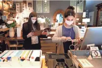  ??  ?? Mary Grace Payne, left, and Heather Mize work behind the counter at Southern Avenue Company inside the Shops of Saddle Creek in Germantown.