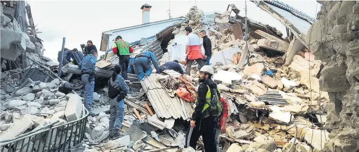  ??  ?? Auch das historisch­e Zentrum von Amatrice ist völlig zerstört. Unter den Trümmern suchten Helfer nach Überlebend­en.