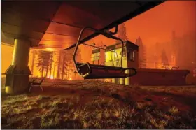  ?? (AP/Noah Berger) ?? The Caldor Fire burns at Sierra-at-Tahoe ski resort on Monday, in Eldorado National Forest, Calif. The main buildings at the ski slope’s base survived as the main fire front passed.