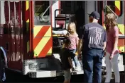  ?? PHOTO BY KIMBERLY K. FU, THE REPORTER ?? David Peuse, 6, and his sister, 4-year-old Kaylee, navigate a fire engine under the watchful eyes of their mom, Jessica, and Vacaville Firefighte­r Brian Whitley.