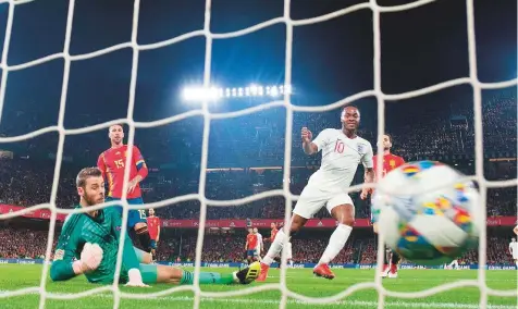  ?? AFP ?? England forward Raheem Sterling (right) scores against Spain’s goalkeeper David de Gea during the Uefa Nations League football match between Spain and England on Monday at the Benito Villamarin stadium in Sevilla, Spain.