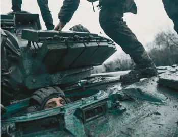  ?? LIBKOS ?? A Ukrainian soldier peers out from inside a captured Russian tank on Tuesday in the Donetsk region of Ukraine.