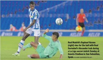  ?? ALVARO BARRIENTOS/AP ?? Real Madrid’s Raphael Varane (right) vies for the ball with Real Sociedad’s Alexander Isak during a La Liga soccer match Sunday at Anoeta Stadium in San Sebastian, Spain.