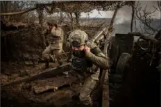  ?? Tyler Hicks/The New York Times ?? Ukrainian soldiers fire in the direction of Avdiivka, Ukraine, on Wednesday. The Biden administra­tion said Saturday that the Ukrainian military withdrawal from Avdiivka was the result of Congress failing to provide additional money to support Kyiv’s war effort.