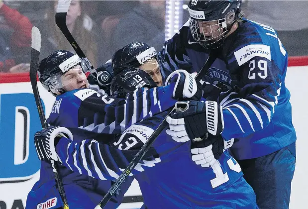  ?? GERRY KAHRMANN/PNG ?? Finland’s Jesse Ylonen, centre, is mobbed after scoring on the U.S. in the world juniors final at Rogers Arena on Saturday.