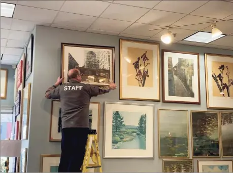  ?? Contribute­d photo ?? A staff member hangs a picture in the showroom of the new Habitat for Humanity ReStore location in Vernon.