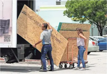  ??  ?? Hialeah, Fla., residents load sheets of strand board on a truck Tuesday as they prepare for Irma.
