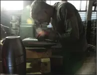  ?? (AP/Evgeniy Maloletka) ?? A worker puts serial numbers on the a mortar shell at a factory in Ukraine in late January.