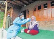  ??  ?? A health worker collecting a woman’s nasal swab outside her home in Budgam on Thursday.
WASEEM ANDRABI/HT