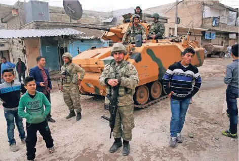  ?? FOTO: AP ?? Türkische Soldaten sichern eine Straße im Zentrum von Afrin. Seit fast zwei Jahren stehen türkische Truppen bereits im Nordwesten Syriens. Im Frühjahr nahmen sie die bis dahin von kurdischen Milizen kontrollie­rte Stadt Afrin ein. Auch hier soll nun...