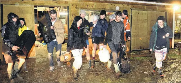  ?? PHOTO: STEPHEN JAQUIERY ?? Help from my friends . . . Josh Adam carries a gas bottle from his Henley sheep, beef and dairy farm with wife EllieMay Adam (right) last night.