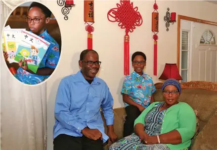  ?? Photos: Xinhua ?? Khaya Njumbe (middle), with his parents in Chicago, United States. INSET: Khaya Njumbe shows his Chinese-learning textbooks in Chicago, the United States, on September 25, 2019.