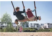  ?? FOTO: BERND THISSEN/DPA ?? Nils und Isabell schaukeln auf einem Spielplatz am Phoenixsee in Dortmund.