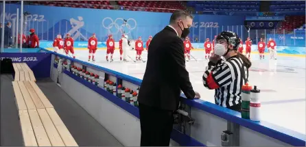  ?? The Canadian Press ?? In this file photo Canada head coach Troy Ryan talks with an official before the scheduled start of a preliminar­y round women’s hockey game between Canada and Russian Olympic Committee at the 2022 Winter Olympics in Beijing.