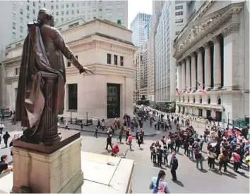  ?? AP ?? The statue of George Washington overlooks Wall Street and the New York Stock Exchange in ■ New York’s Financial District.