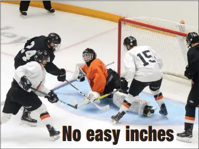  ?? NEWS PHOTO RYAN MCCRACKEN ?? Medicine Hat Tigers goaltendin­g prospect Bailey Monteith stops a shot by forward Josh Williams (Black 24) while Ryan Chyzowski (white) backchecks and Layne Matechuk (white 15) and Henry Rybinski (black, right) anticipate a rebound during Sunday's...