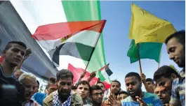  ??  ?? Palestinia­ns wave national and Egyptian flags to celebrate the reconcilia­tion agreement between Hamas and Fatah in Gaza City on Thursday.