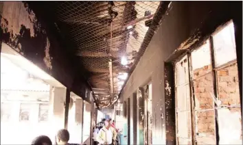  ??  ?? Residents of Matapi Hostels in Mbare lost property worth thousands of dollars when the flats went up in smoke on Monday evening. In the picture some residents are seen assessing the damage.— (Picture by Aaron Nyamayaro)