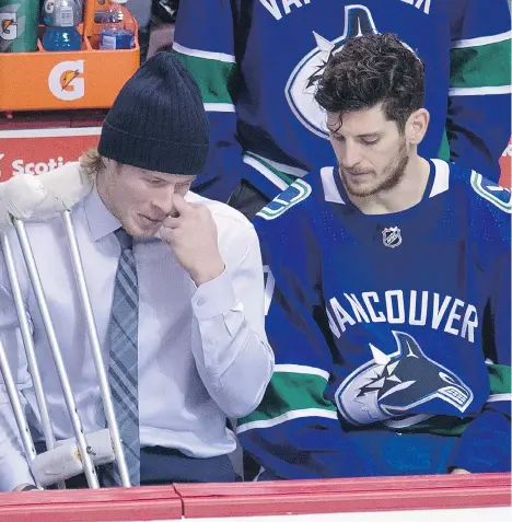  ?? JONATHAN HAYWARD/THE CANADIAN PRESS ?? Canucks fans expected the worst Sunday when right-winger Brock Boeser, seen with teammate Nic Dowd, was on crutches and wearing a walking boot after blocking a shot during their loss to Calgary. Boeser, however, has a bone bruise and is day to day.